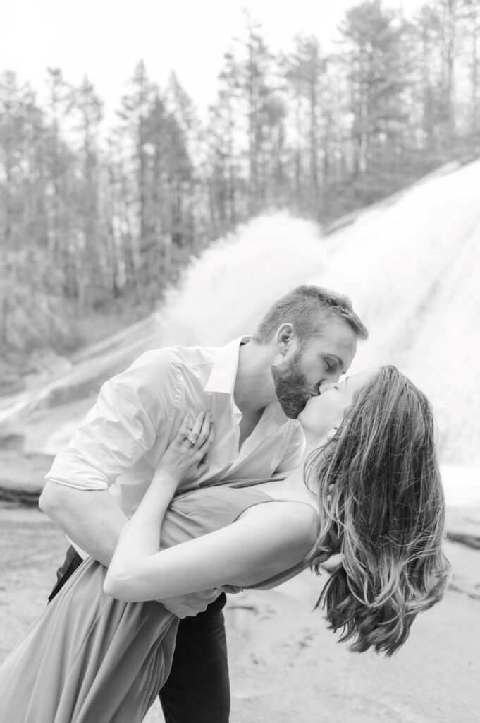black and white photo man dips woman as they kiss Greenville engagement session 