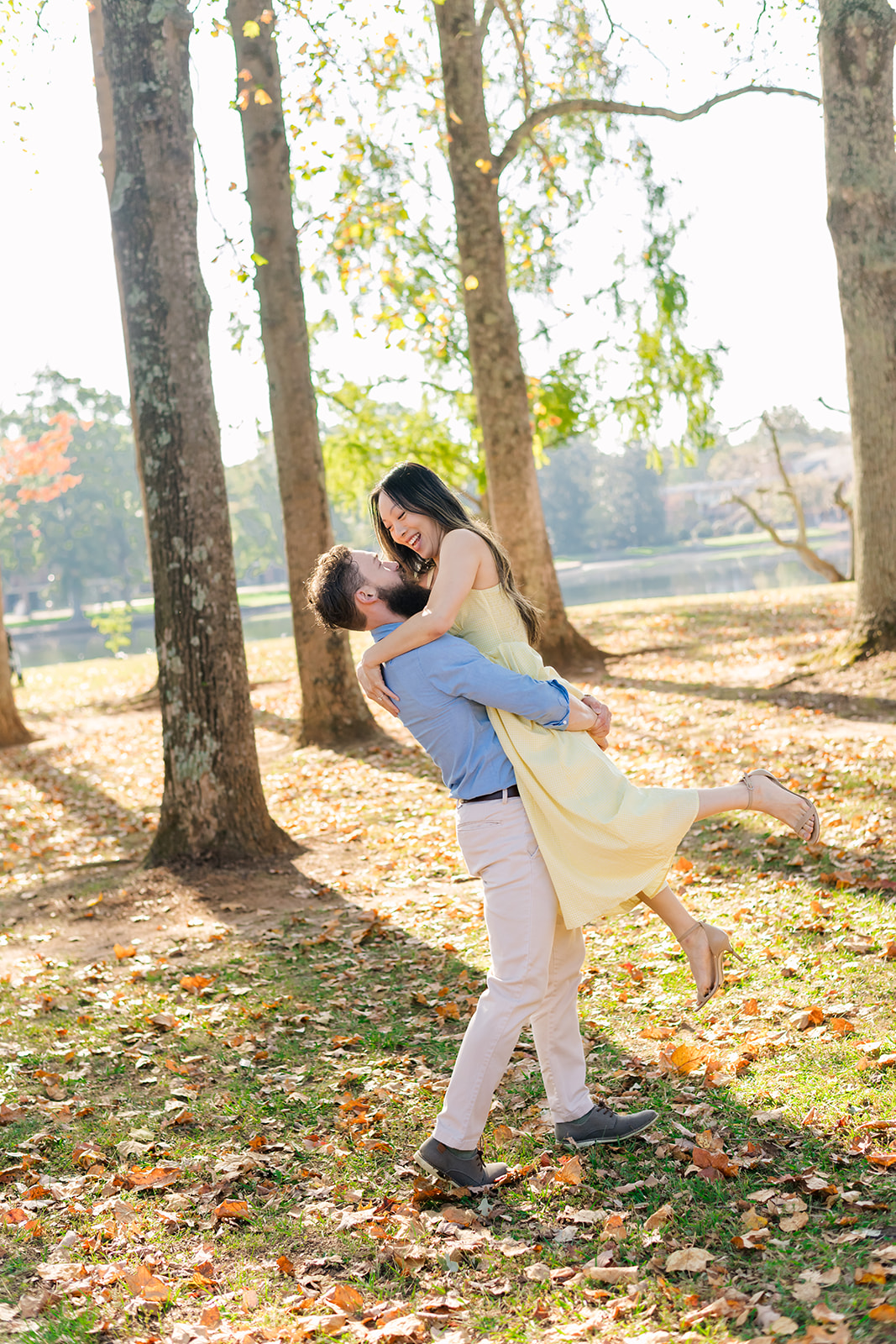 Couple with woman wearing long yellow dress spinning in the forest