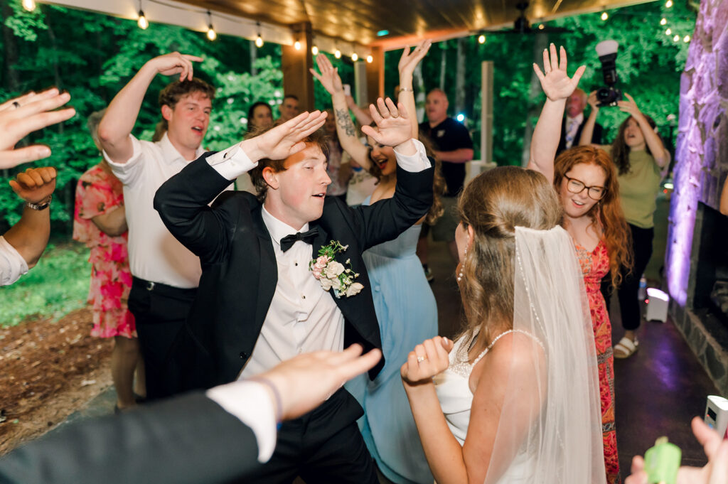 bride and groom dancing with friends surrounding them at the reception at piney grove ranch wedding