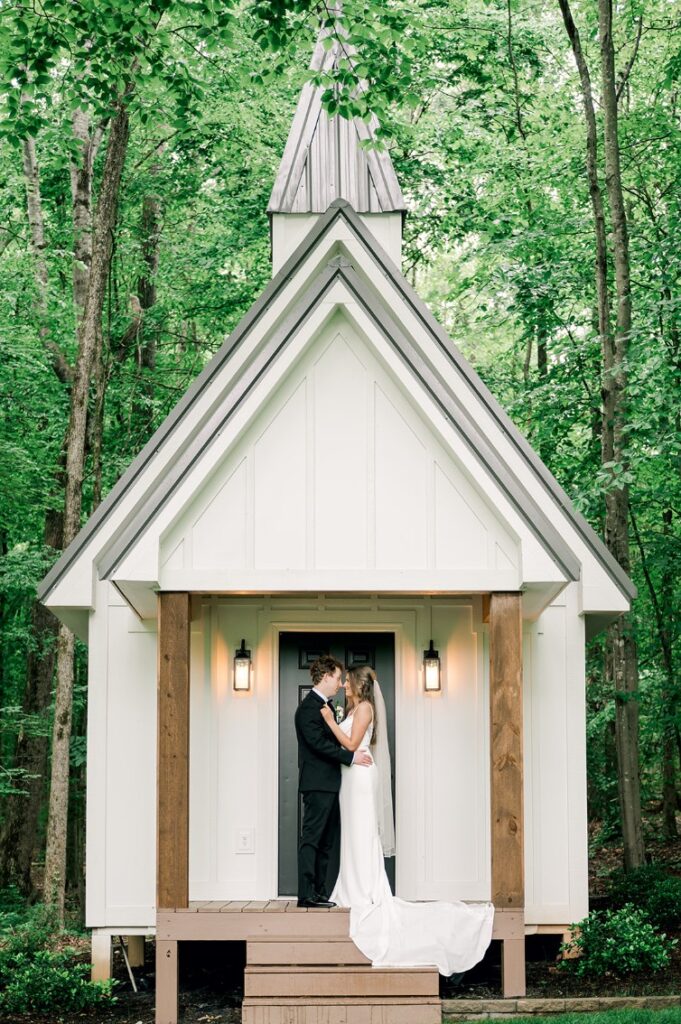 bride and groom stand in front of small shelter at piney grove ranch wedding