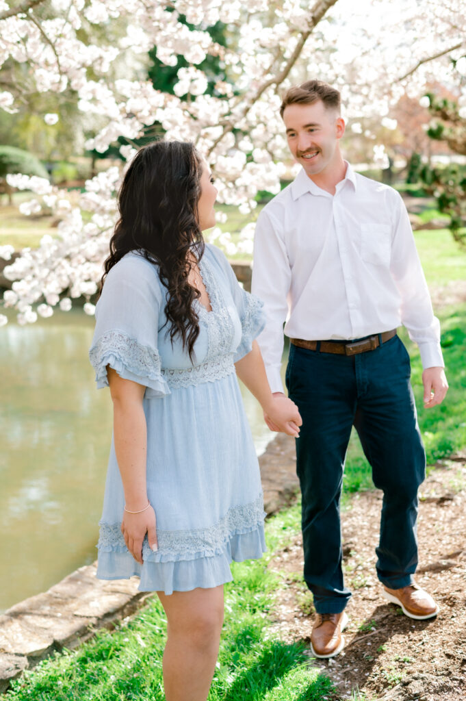 Girl wearing blue dress looking admiringly at fiance with white collared shirt at Furman University in Greenville SC
