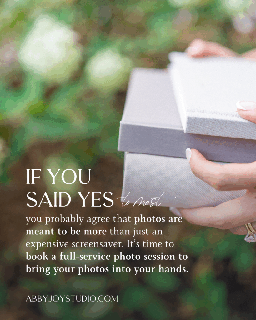 Female hands holding photo albums in front of hydrangea bush 