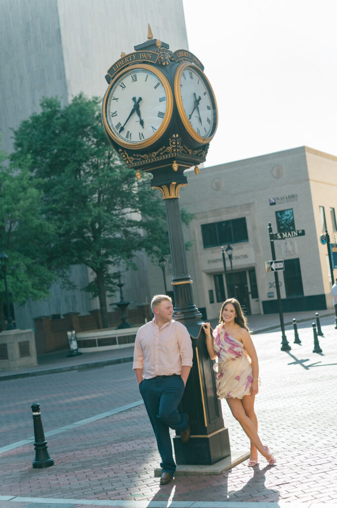 Engagement photos standing at the clock outside M. Judson in Greenville SC