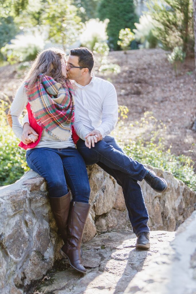 Couple's kissing portrait on Rock Quarry Garden's stone bridge