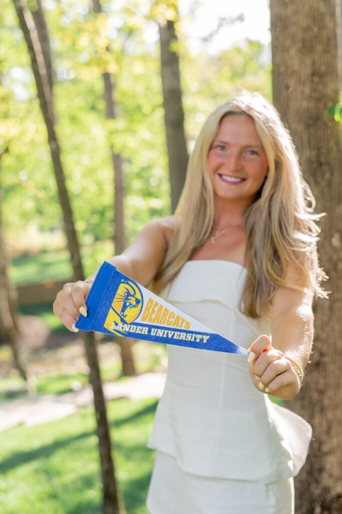 Senior showcasing college penant