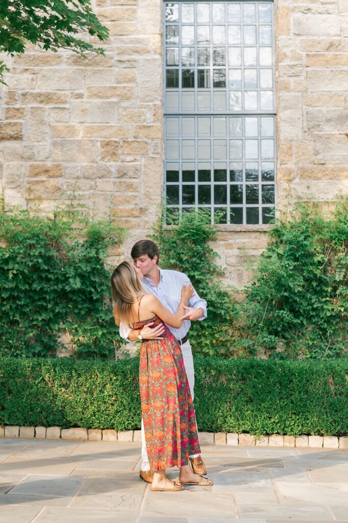 Couple kiss in front of Founder's Hall for the Reserve at Lake Keowee engagement