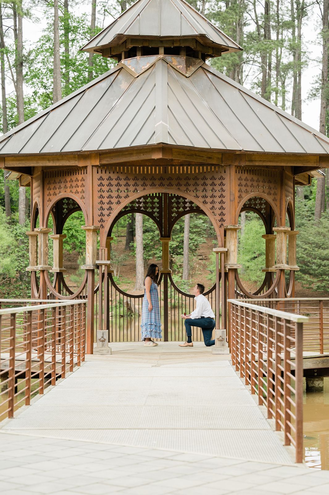 Man kneeling to propose at the Clemson Botanical garden gazebo